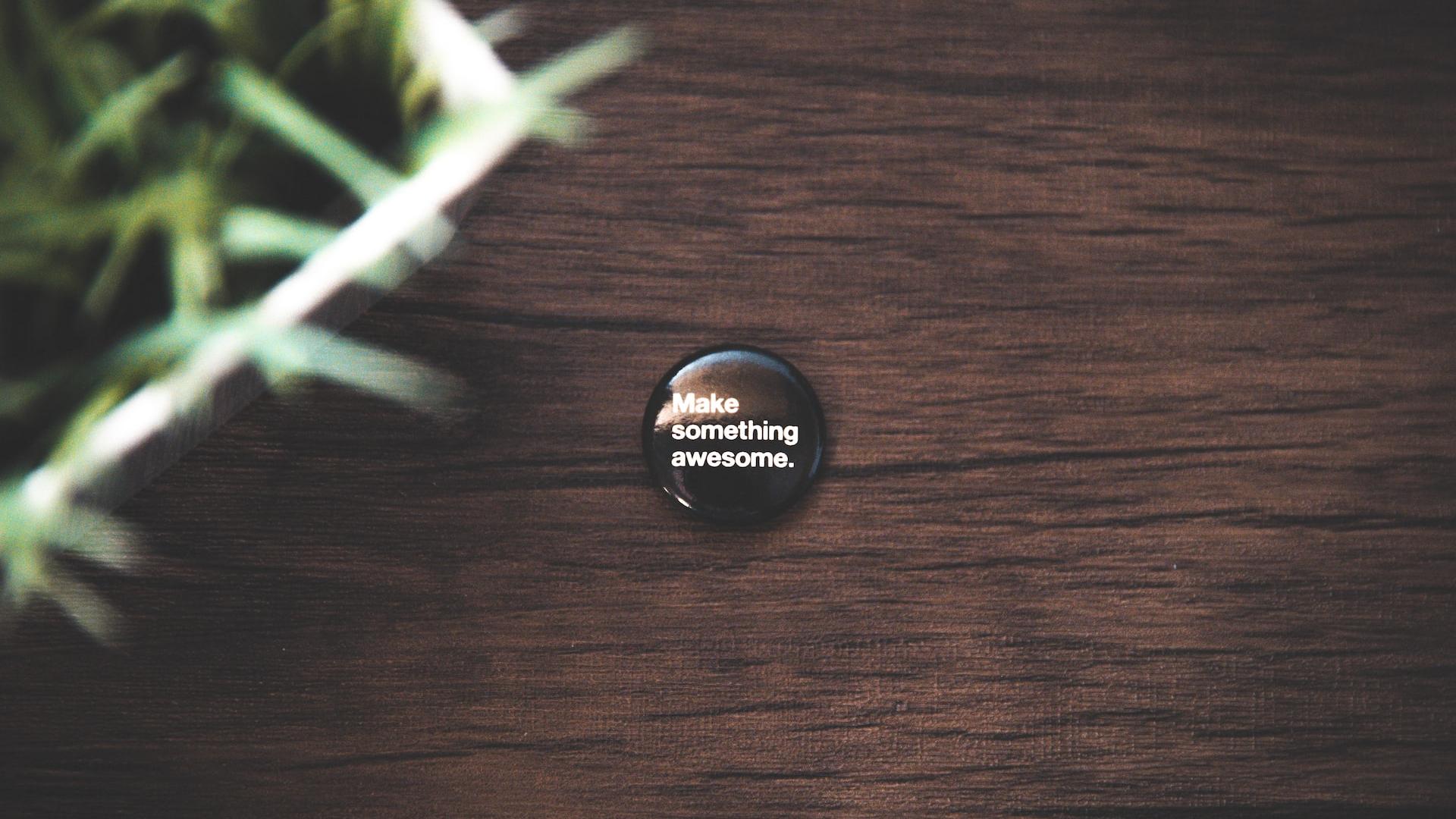 round black button pin on brown wooden surface